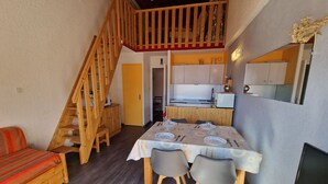 Un interior acogedor con comedor, escalera de madera y cocina.