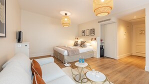 A modern, well-lit bedroom with a bed, bedside tables, and a wardrobe. - Le Nest by Sweett (Paris)
