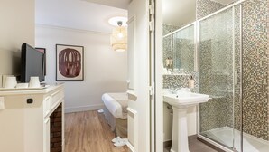 A modern bathroom with a shower area, a sink, and a toilet. - Le Nest by Sweett (Paris)