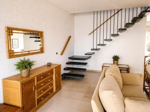 A modern interior with a staircase, a wooden cabinet, a mirror, and a sofa. - Stunning 6-Bedroom Villa in Platja d’Aro, Steps from Beach with Terrace (Platja d'Aro)