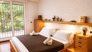 Une chambre moderne avec un grand lit, une tête de lit en bois et une table de chevet dotée de tiroirs.