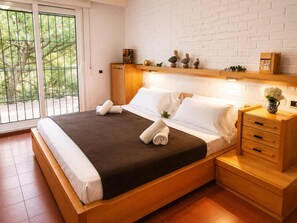 Une chambre moderne avec un grand lit, une tête de lit en bois et une table de chevet dotée de tiroirs.
