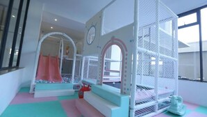 A children's play area with a slide, climbing net, and soft play surfaces. - Lux Suites Perry West Luxurios Apartment (Nairobi)