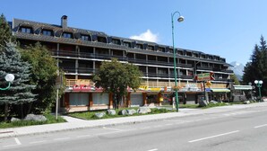A multi-story hotel with balconies, a restaurant, and a sign for 'Le Jandri'. - Modern Duplex Near Slopes, Ski Access (Les Deux Alpes)