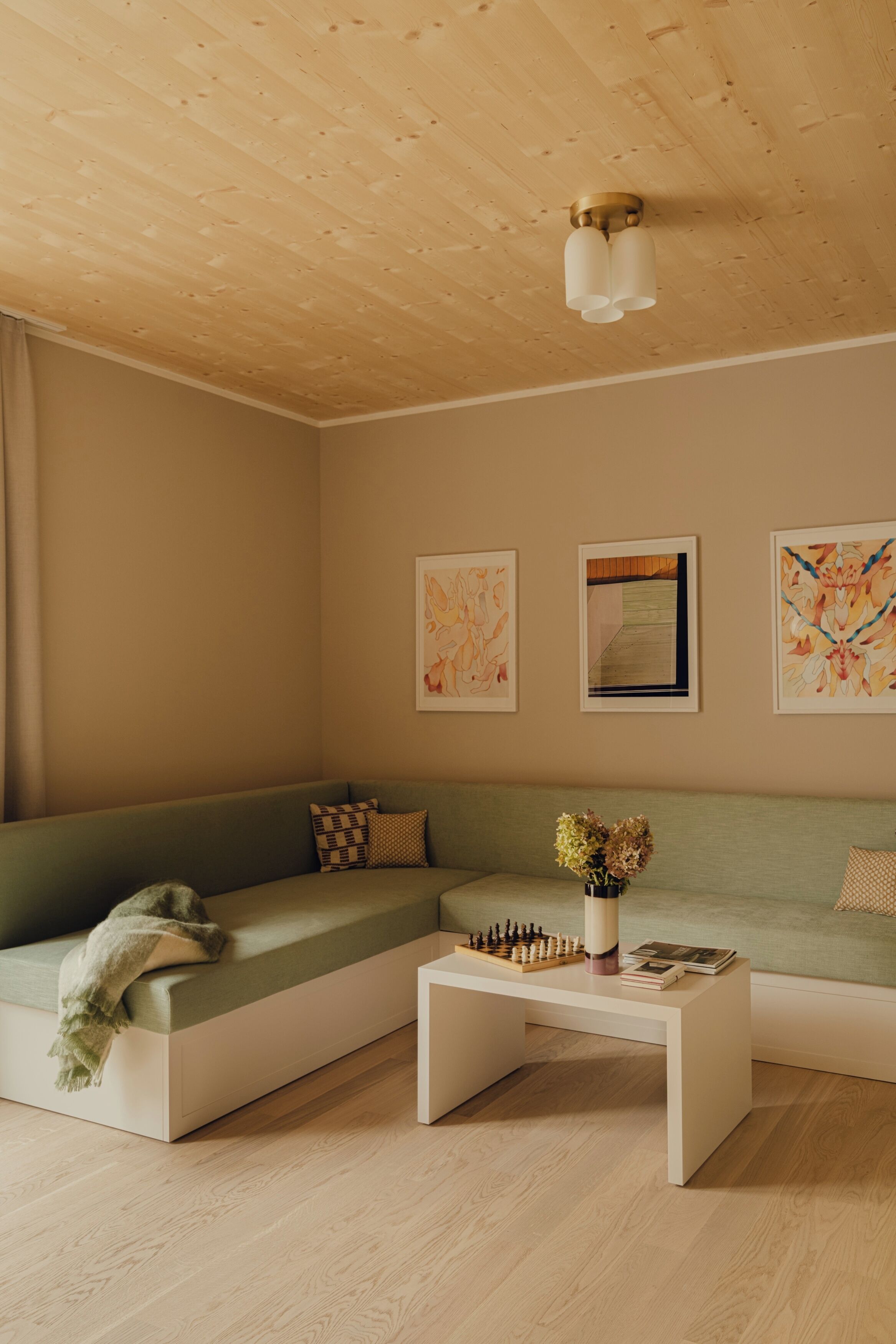A modern living room with a sectional sofa, a coffee table, and wall art.