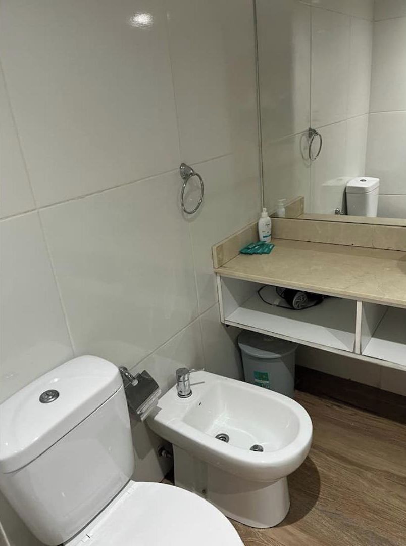 Un baño con inodoro, bidé y lavamanos.