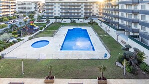 A residential complex with a swimming pool, multiple balconies, and a playground.