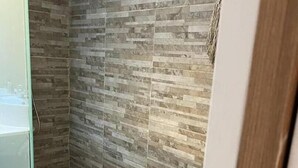 A bathroom with a tiled wall and wooden flooring. - Muy Bien Ubicado y Comodo (ABN)