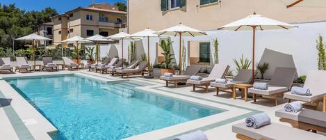 A poolside area with lounge chairs and umbrellas.