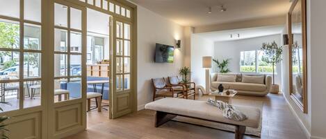 A spacious living area with a sofa, chairs, a coffee table, and a large window.