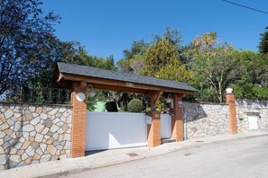 Een toegangspoort met een stenen muur en een overdekte veranda.