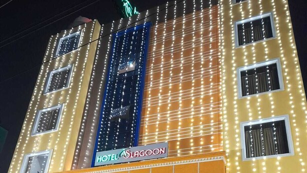 Un hotel con un letrero que dice "HOTEL SLAGOON" y una entrada iluminada en azul.