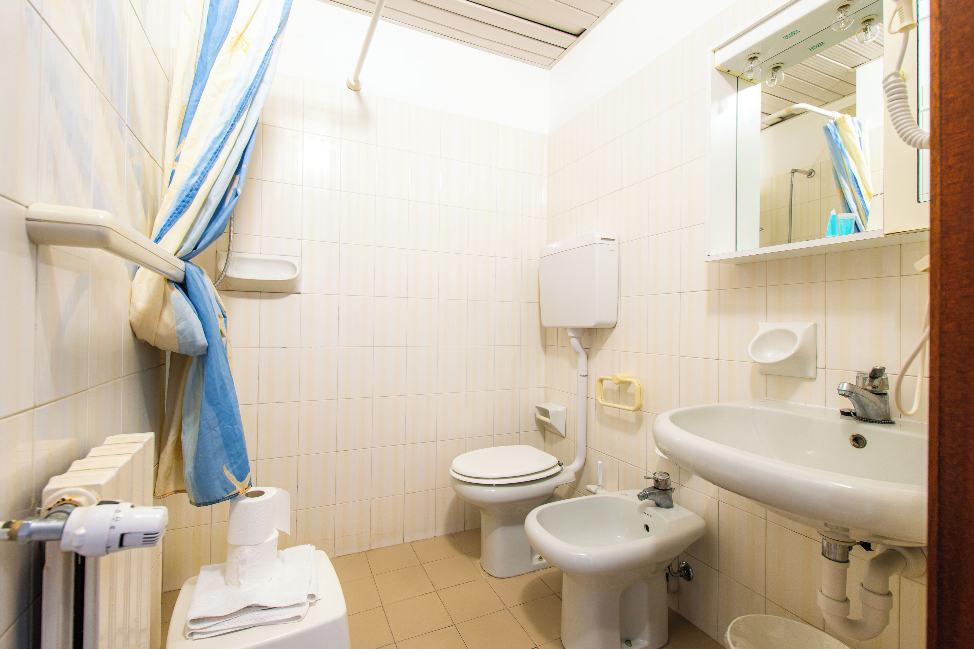 A bathroom with a toilet, bidet, and sink.