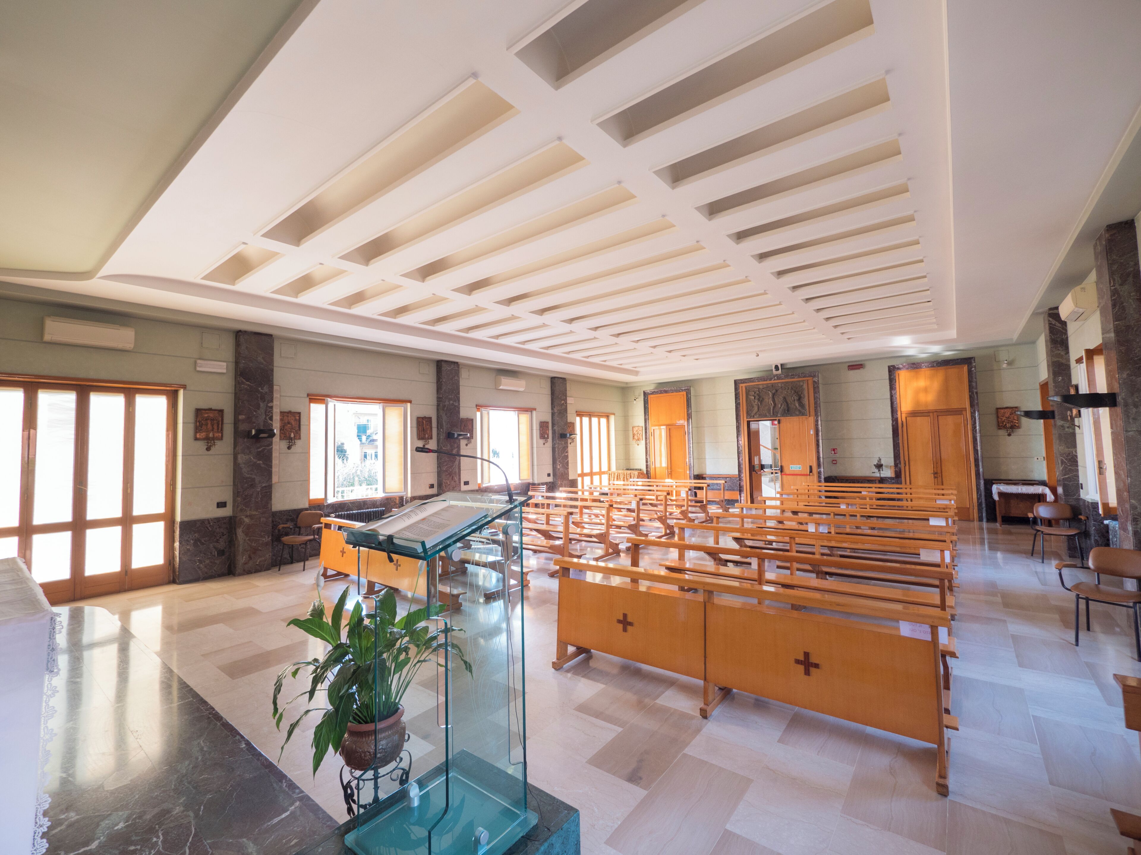 A church interior with pews, a pulpit, and a large window.