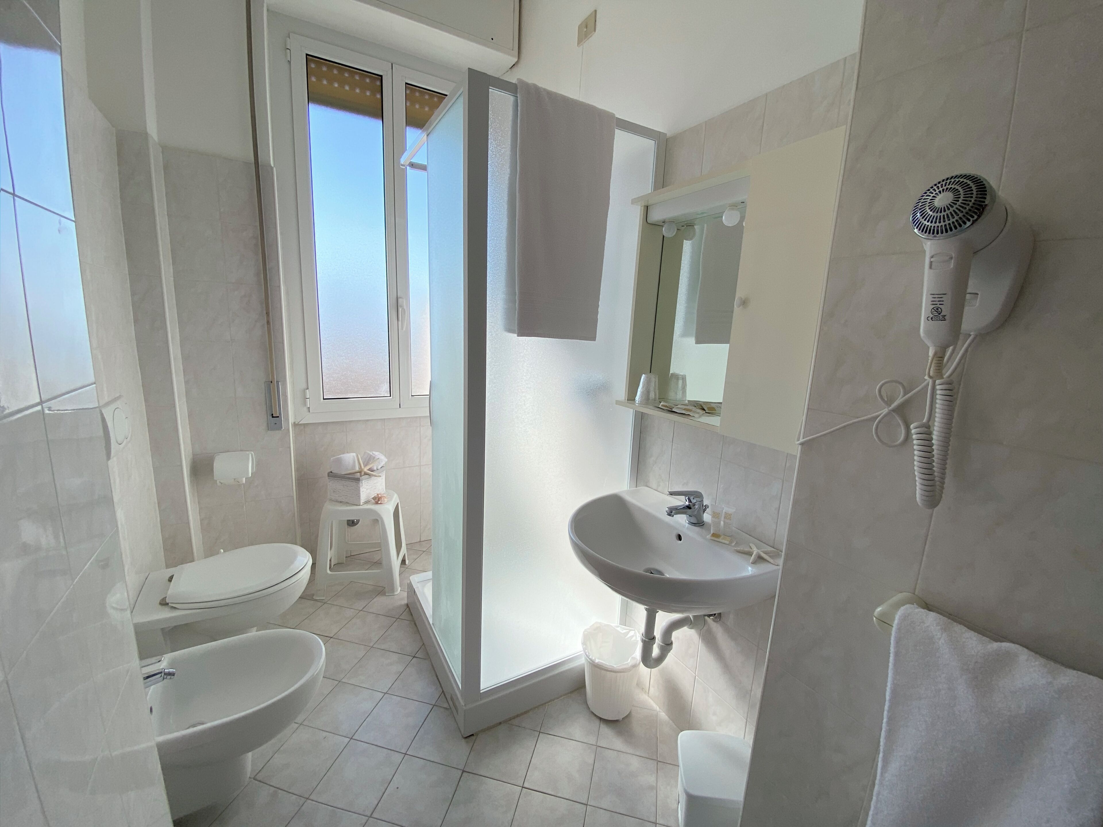 Een badkamer met toilet, wastafel en douche.