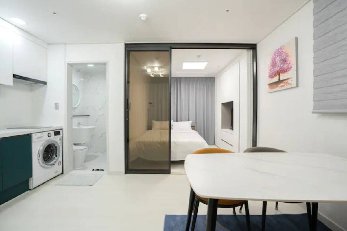 Une chambre d’hôtel moderne dotée d’une cuisine, d’un coin repas et d’une chambre à coucher.