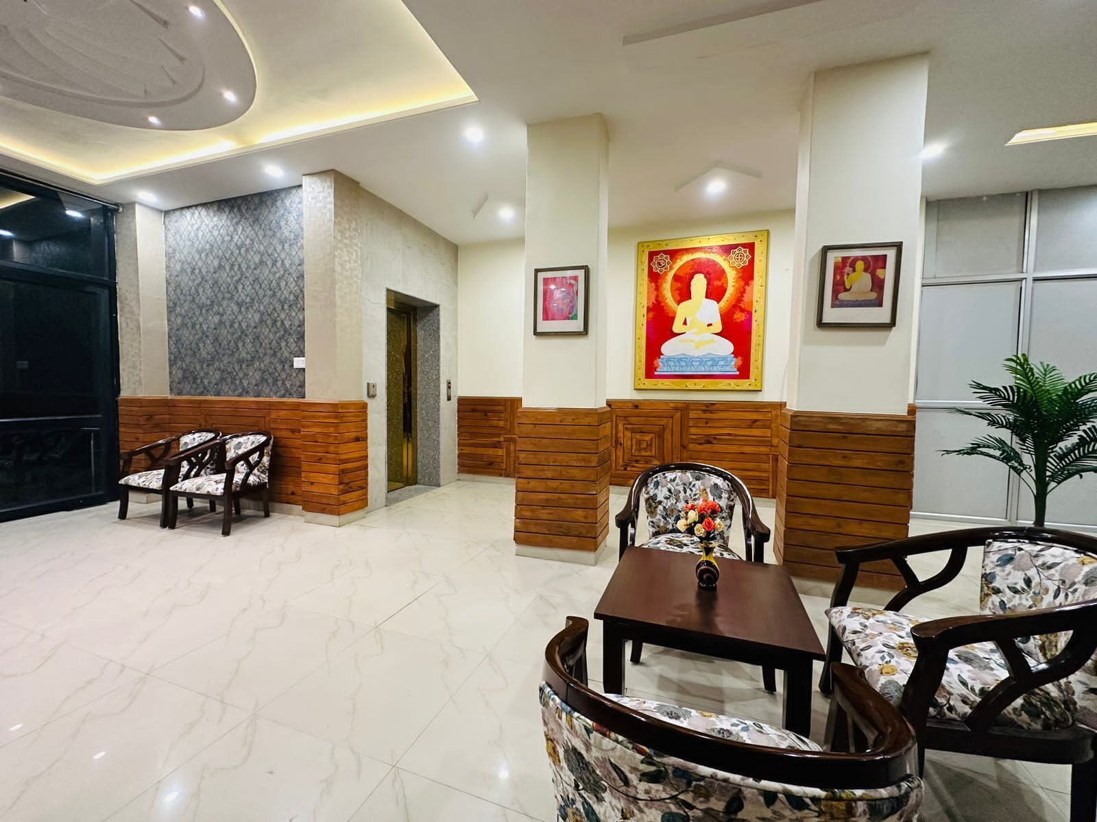 A lobby with a reception desk, seating area, and a wall with religious artwork.