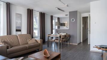 Un salon moderne avec un canapé, une table basse et un coin repas.