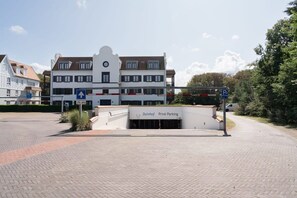 A building with a sign for 'Duinhoff Privé Parking' and a blue parking sign.