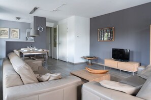 A modern living room with a sofa, coffee table, and television.