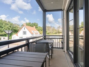 A balcony with a view of a house and trees.