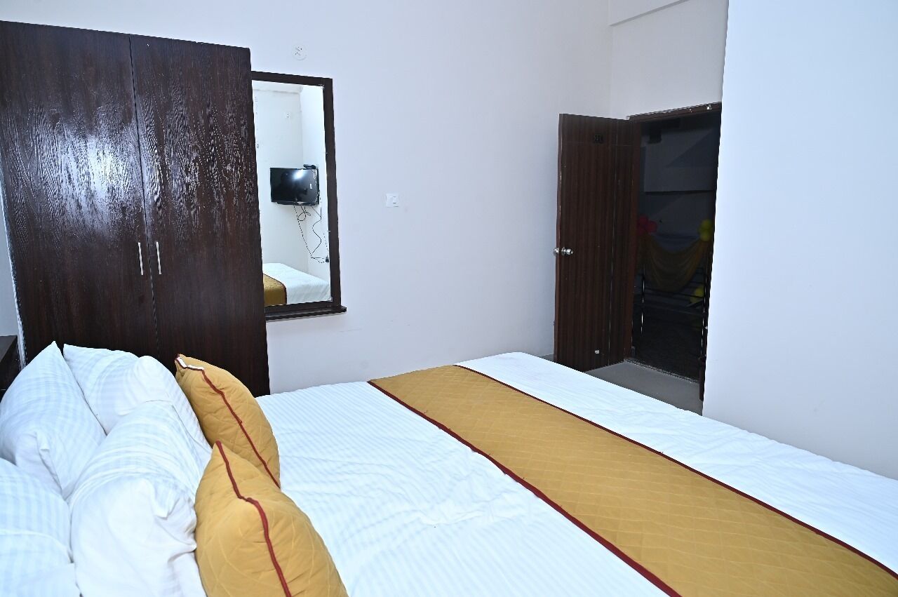 A bedroom with a bed, a wardrobe, and a mirror.