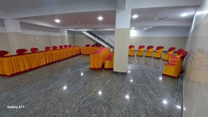 A conference room with a long table and chairs, a staircase, and a polished floor. - Hotel SLN Comfort (Tumkur)