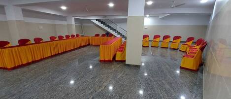 A conference room with a long table and chairs, a staircase, and a polished floor.