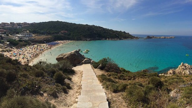 A coastal view with a beach, rocky outcrops, and a path leading down to the water. - Bungalow D'elite a Capo Testa (Capo Testa)
