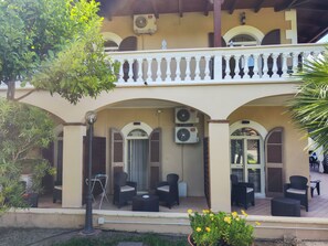A building with a balcony, outdoor seating area, and two air conditioning units. - Villa Antonietta Ischia  (Forio)