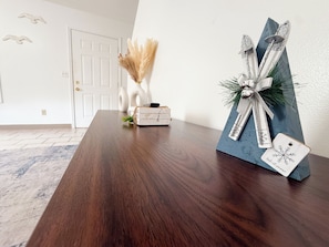 A wooden table with a decorative gift box and a small white vase with dried pampas grass. - Spacious 3BR/2BA Home – Queen Beds + TVs in Every Room (Macomb)
