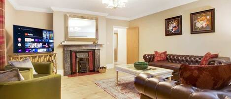 A living room with a fireplace, a television, a sofa, and a coffee table.