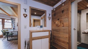 Um interior moderno com uma parede de destaque em madeira, um espelho e cabeças de animais montadas.