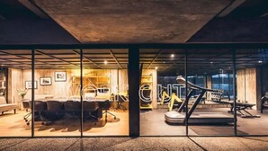 A modern interior with glass walls, a conference room, and a gym area. - Eco Loft with Terrace Garden & Gym Access (Ciudad de México)