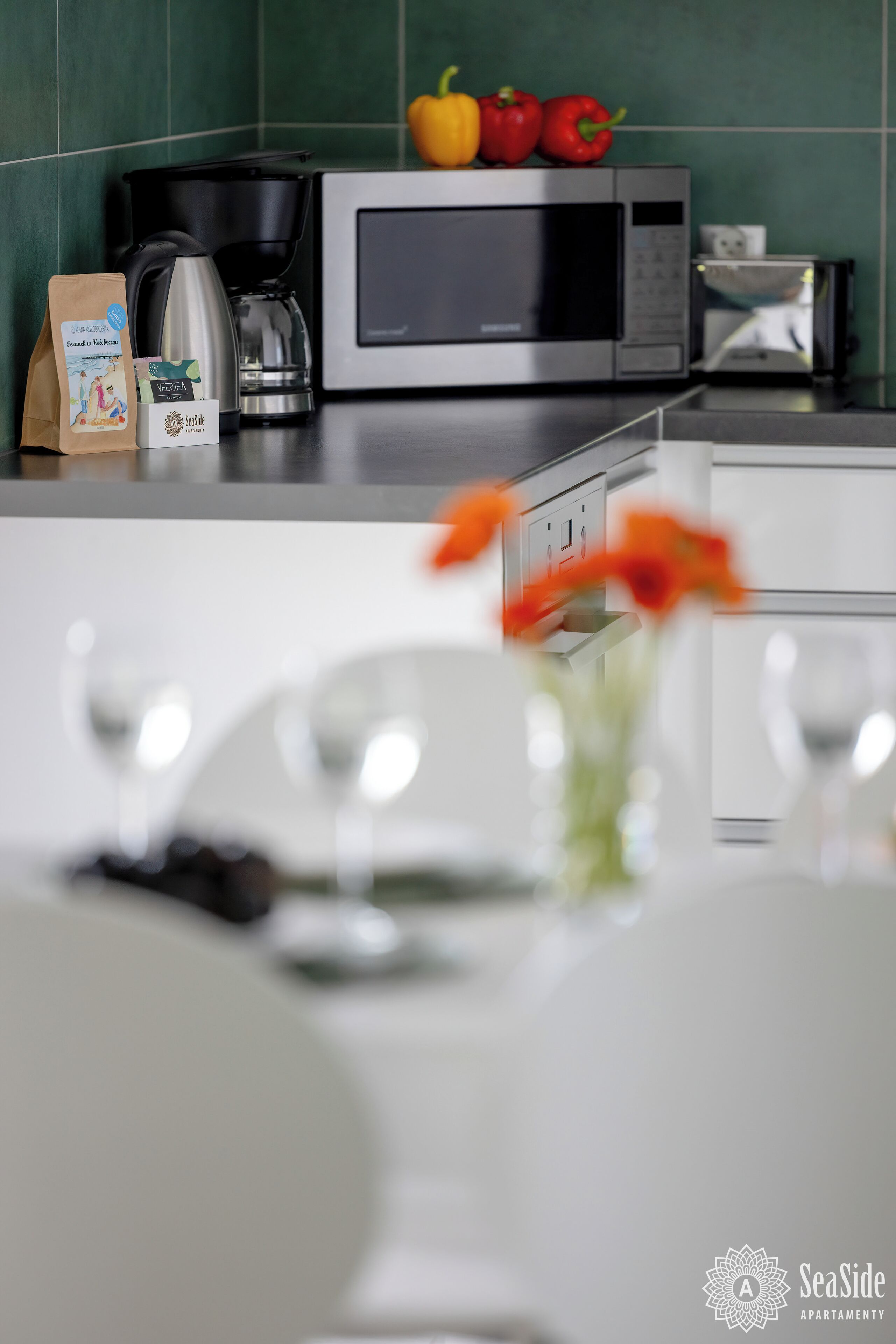 A kitchen with a microwave, coffee maker, and a bag of coffee.