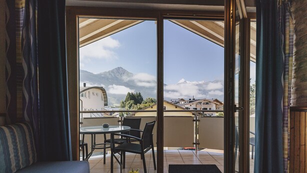 A balcony with a table, chairs, and a sofa. - Appartement Haus Elise - TOP 3, balcony & mountain view (Zell am See)