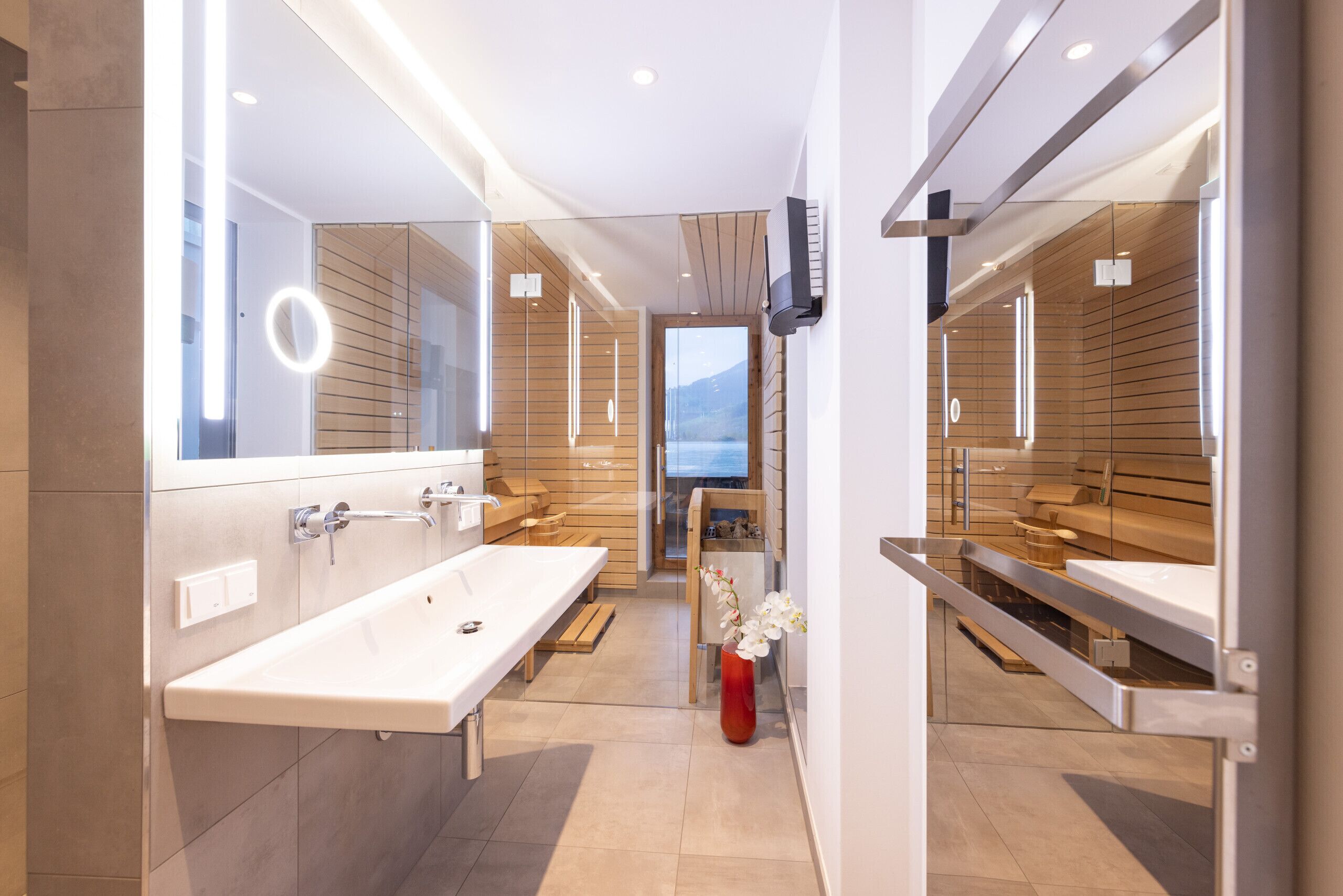 Une salle de bain moderne avec deux lavabos, un grand miroir et une vue sur les montagnes.