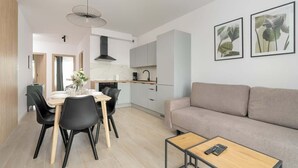 Un espacio habitable moderno con comedor, cocina y sofá.