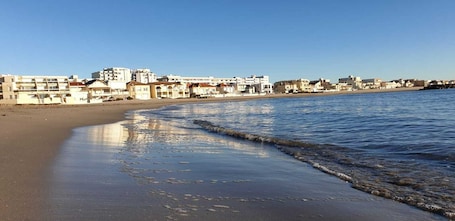 On the beach, white sand, beach umbrellas, beach volleyball. Clair de Lune