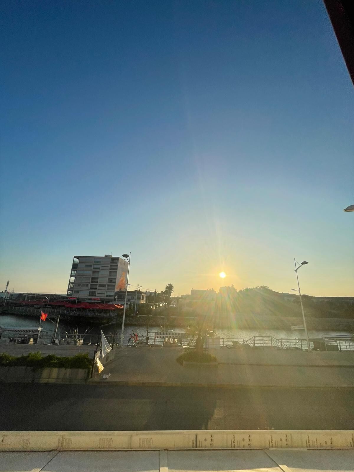 A view of a waterfront area with a building and a sunset.