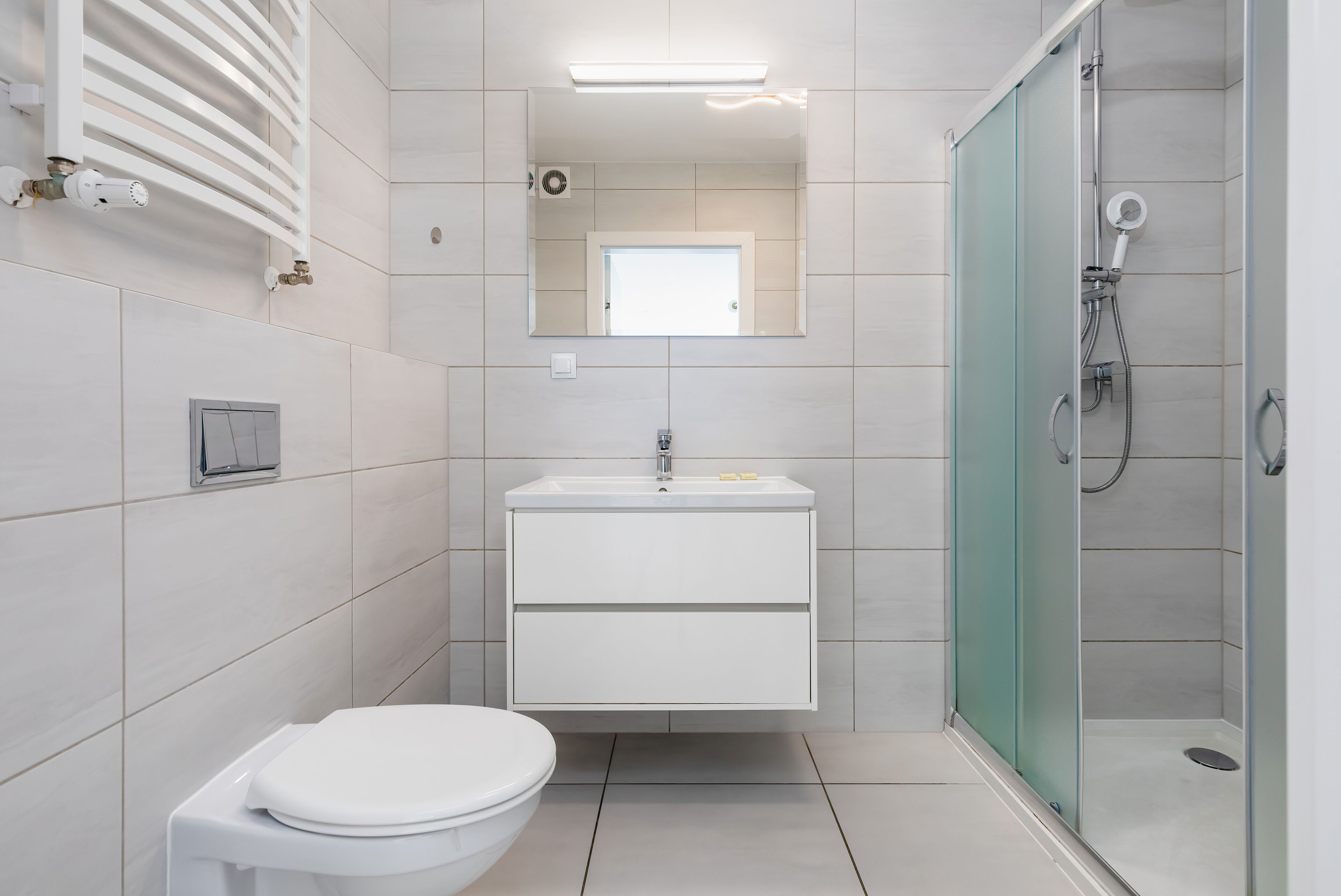 Ein modernes Badezimmer mit Toilette, Waschbecken und Dusche.