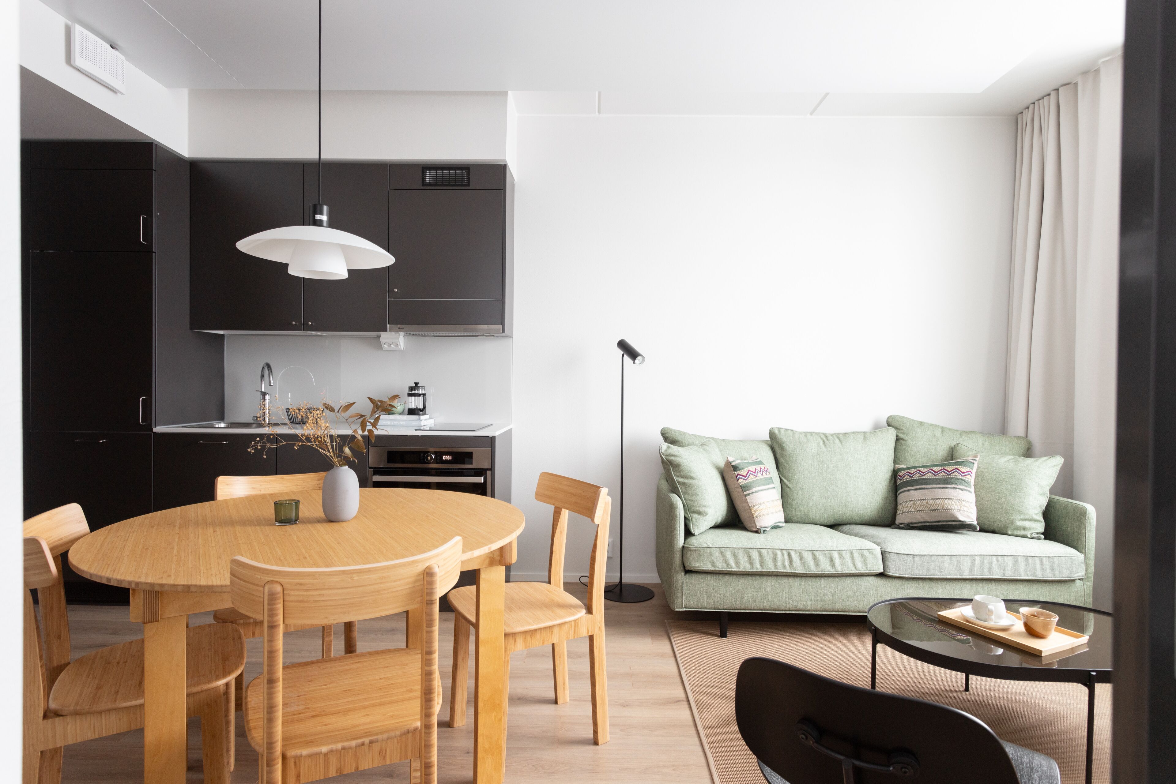 Ein stilvolles Wohnzimmer mit Essbereich, einer Couch und einem Couchtisch.