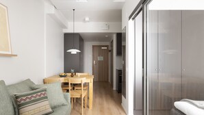 A modern living room with a sofa, a dining table, and a kitchen area. - Noli Otaniemi (Espoo)