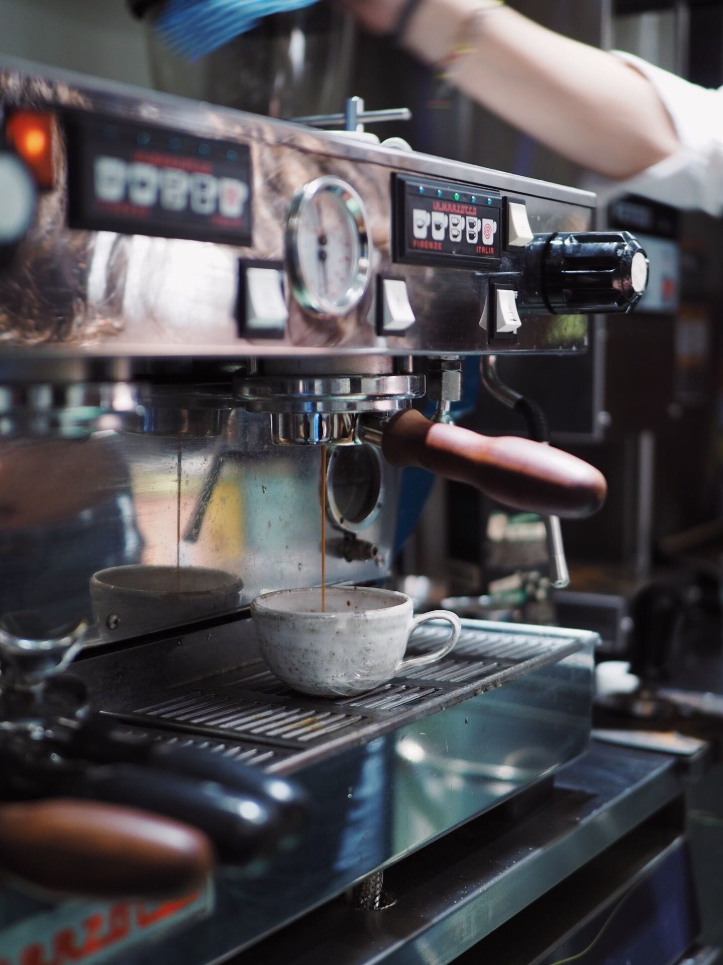 A coffee machine with a cup of coffee being brewed.