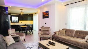 A modern living room with a sofa, armchairs, a coffee table, and a TV. - BEAUTIFUL 4 BEDROOM VILLA WITH PRIVATE POOL&GARDEN IN HEART OF DALYAN MARAS AREA (Dalyan)