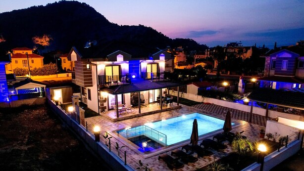 A modern villa with a swimming pool, outdoor seating, and a view of the surrounding hills. - BEAUTIFUL 4 BEDROOM VILLA WITH PRIVATE POOL&GARDEN IN HEART OF DALYAN MARAS AREA (Dalyan)