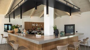 A modern kitchen with a central island, bar area, and seating. - Mare Garden (Apokoronas)