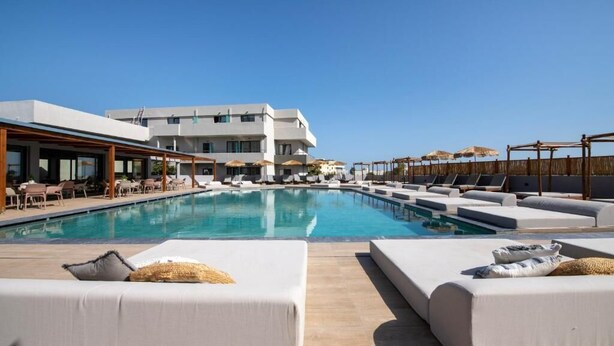 A poolside area with sun loungers and a large pool. - Mare Garden (Apokoronas)