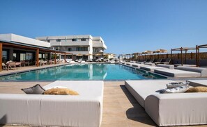 A poolside area with sun loungers and a large pool. - Mare Garden (Apokoronas)