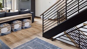 Un intérieur moderne comprenant un escalier, un coin salon et un téléviseur à écran plat.